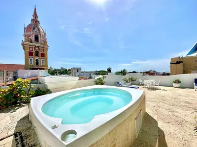 a bath tub on top of a building with a clock tower at By Calamari Homes - Ayos 206 - Walled City in Cartagena de Indias