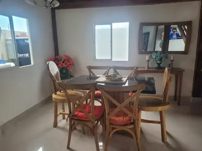a dining room with a table with chairs and a mirror at Hostal Casa Adela