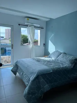 a blue bedroom with a bed and a window at Acogedor apartamento con súper ubicación in Barranquilla