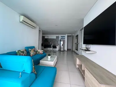a living room with a blue couch and a flat screen tv at Azurea Beach in Cartagena de Indias