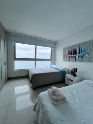 a bedroom with two beds and a large window at Azurea Beach in Cartagena de Indias