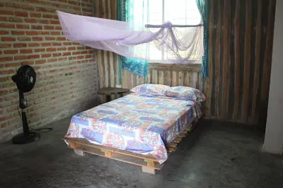 a bedroom with a bed in a room with a window at Casa Grulla in Santa Marta
