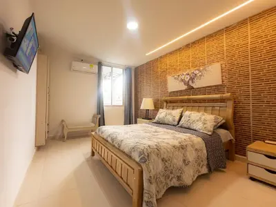 a bedroom with a bed and a brick wall at CALA Estancias Urbanas, Apartamentos & Suites in Barranquilla