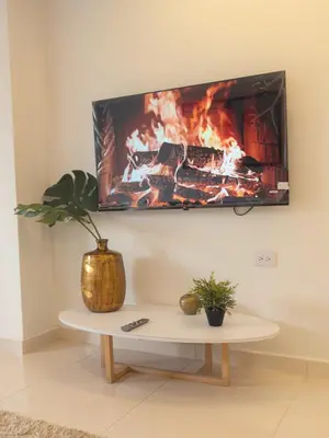 a living room with a fireplace with a tv on the wall at CALA Estancias Urbanas, Apartamentos & Suites in Barranquilla