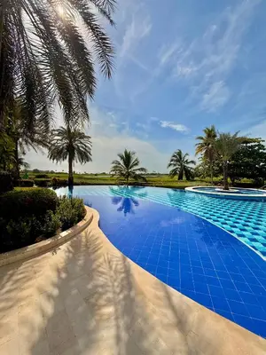 a blue swimming pool with palm trees in the background at Karibmed Cartagena in Cartagena de Indias