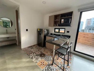 a kitchen with a table and a refrigerator at Deluxe Suite with Terrace in Barranquilla