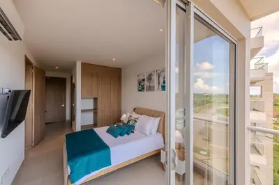 a bedroom with a bed and a sliding glass door at Cartagena getaway - Laguna Cristalina - 2BR - 7 pax in Cartagena de Indias