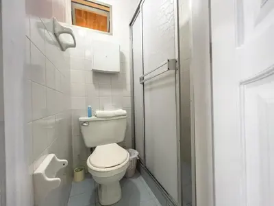 a small bathroom with a toilet and a shower at Caribbean Sunset - Apartamento con salida a la playa in Cartagena de Indias