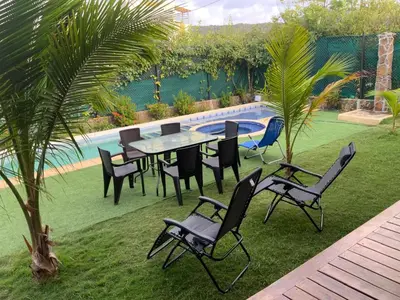 a table and chairs in a yard next to a pool at Habitacion doble en Villakite ,Salinas del Rey in Juan de Acosta