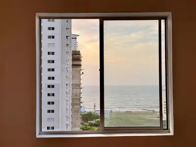 a window with a view of a building and the ocean at Modern Apartment with Ocean Views in Cartagena de Indias