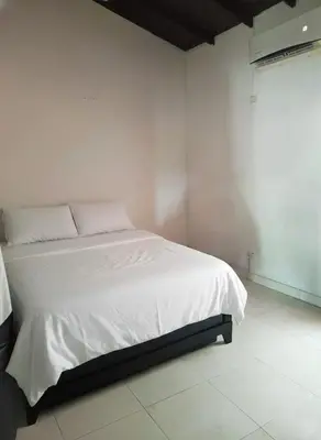 a bedroom with a white bed with white sheets at La Cabana de Isaac Boquilla in Cartagena de Indias
