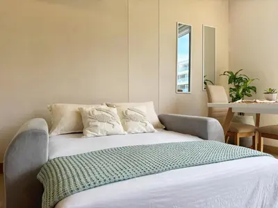 a bedroom with a bed with white sheets and a table at Spectacular view of the Caribbean Sea in Cartagena de Indias