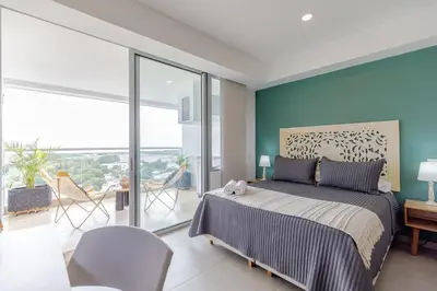 a bedroom with a bed with a blue wall at Encantador y moderno estudio con piscina a pasos del aeropuerto in Cartagena de Indias