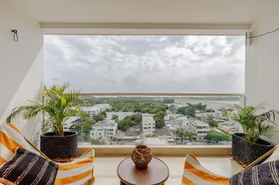 a room with a large window with chairs and a table at Encantador y moderno estudio con piscina a pasos del aeropuerto in Cartagena de Indias