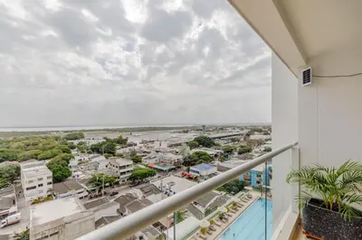 a balcony with a view of a city at Encantador y moderno estudio con piscina a pasos del aeropuerto in Cartagena de Indias