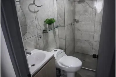 a bathroom with a toilet and a sink with a potted plant at Cartagena Piscina, playa y cerca centro Historico in Cartagena de Indias