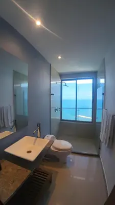 a bathroom with a toilet and a sink and a window at Sky Ocean View in Cartagena de Indias