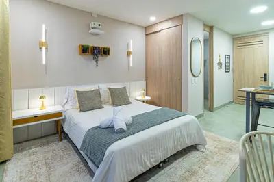 a bedroom with a large bed and a bathroom at Santa Marina Apartments and Beach Club by Xarm Apartments in Santa Marta
