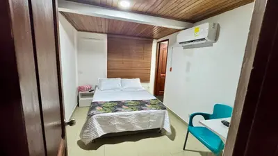 a small room with a bed and a blue chair at Apartamento familiar, frente al mar, Bocagrande in Cartagena de Indias