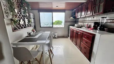 a kitchen with a counter and a table and chairs at Apartamento familiar, frente al mar, Bocagrande in Cartagena de Indias