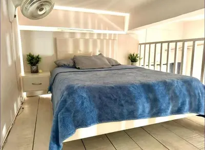 a bedroom with a bed with a blue blanket at Exclusive Studio Apartment in the Old City Cartagena in Cartagena de Indias