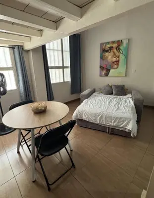 a bedroom with a bed and a table with chairs at Exclusive Studio Apartment in the Old City Cartagena in Cartagena de Indias