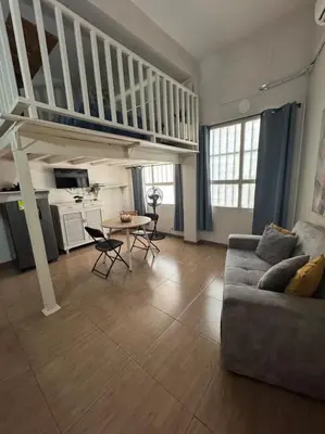 a living room with a couch and a staircase at Exclusive Studio Apartment in the Old City Cartagena in Cartagena de Indias
