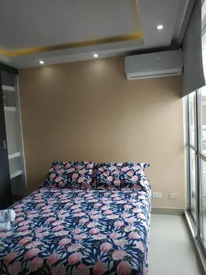 a bedroom with a bed with a floral comforter at Cartagenafantastica in Cartagena de Indias