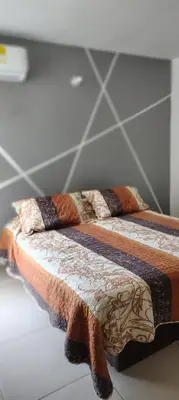 a bed with a comforter and pillows on it at Cartagenafantastica in Cartagena de Indias