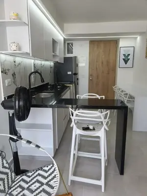 a kitchen with a black counter top and a stool at Apartamento en Cartagena amoblado con vista al mar in Cartagena de Indias