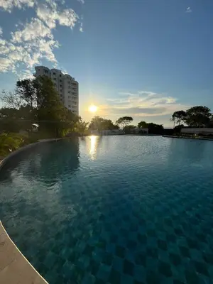 a large swimming pool with a sunset in the background at Santa Marina Santa Marta - By INMOBILIARIA VS in Santa Marta