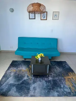 a blue couch in a living room with a table at Vacaciones en el Caribe - Laguito Cartagena al lado de bocagrande in Cartagena de Indias