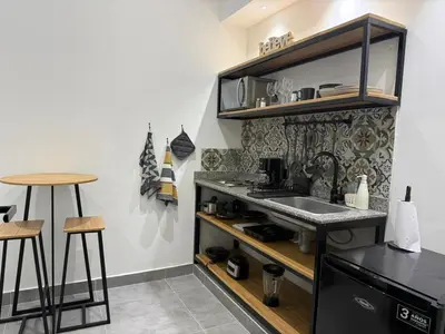 a kitchen with a sink and a counter with stools at Living Sincelejo in Sincelejo