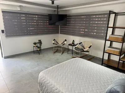 a bedroom with a bed and two chairs and a table at Living Sincelejo in Sincelejo