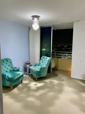 a living room with two chairs and a chandelier at Apartamento en villa campestre Barranquilla in Barranquilla