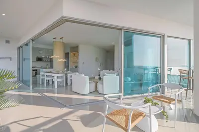a living room with glass walls and a table and chairs at Luxury a 100 Mts del Mar en Edificio SeaWay in Cartagena de Indias