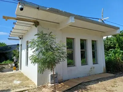 a small white house with a tree in front of it at Apartaestudio en Tierra Bomba in Isla de Tierra Bomba