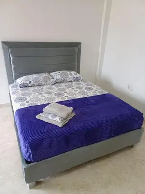 a bed with a purple comforter and two towels at Apartaestudio en Tierra Bomba in Isla de Tierra Bomba