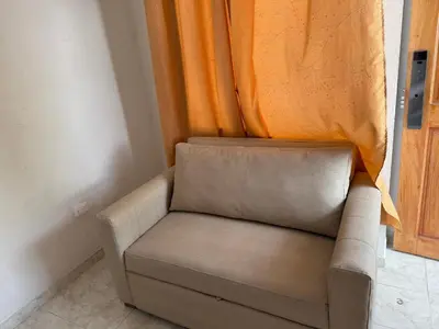 a couch in a room with an orange curtain at Emperatriz I in Cartagena de Indias