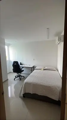 a bedroom with a bed and a desk and a chair at Apartamento en Cartagena Marbella in Cartagena de Indias