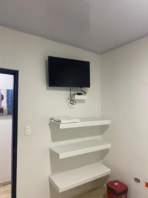 a flat screen tv on a white wall at Hotel Nellamar in Puerto Colombia