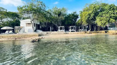 a group of chairs sitting on a beach in the water at Puerto idilio beach resort in Isla Grande
