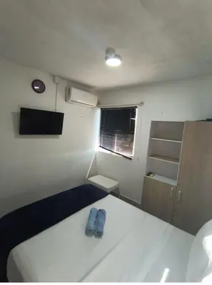 a bedroom with a bed with a pair of blue slippers on it at 406 Sea Breeze and Luxury in Cartagena in Cartagena de Indias