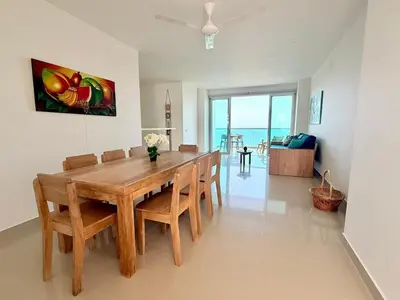 a dining room with a wooden table and chairs at Hermoso Apartamento Frente al Mar 3 Habitaciones AR54 in Coveñas