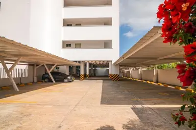 a large white building with a parking lot at Hermoso Apartamento Frente al Mar 3 Habitaciones AR54 in Coveñas