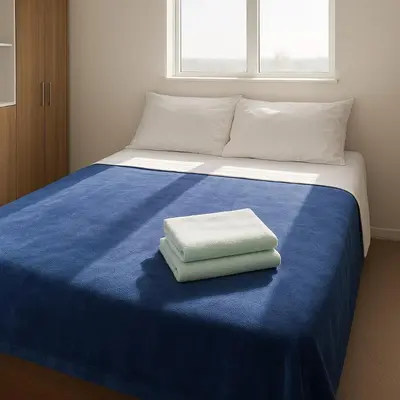 a bed with a blue blanket and two towels on it at Piso 2206 Mirador de Cartagena in Cartagena de Indias