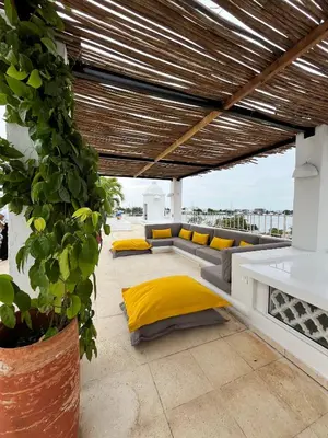 a living room with yellow pillows and a couch at Casa Miramar by Soho in Cartagena de Indias
