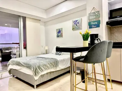 a bedroom with a bed and a table and a desk at CARTAGENA BEACHT - APARTAESTUDIO A 100 mt del mar - Piscina, Jacuzzi in Cartagena de Indias