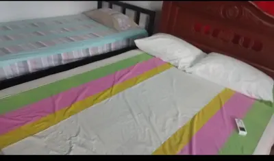 a twin bed with a colorful blanket and pillows at Hospedaje el Floral in Tolú