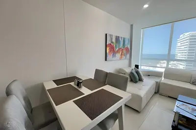 a white living room with a table and a couch at Exclusivo apartamento vista al mar in Santa Marta
